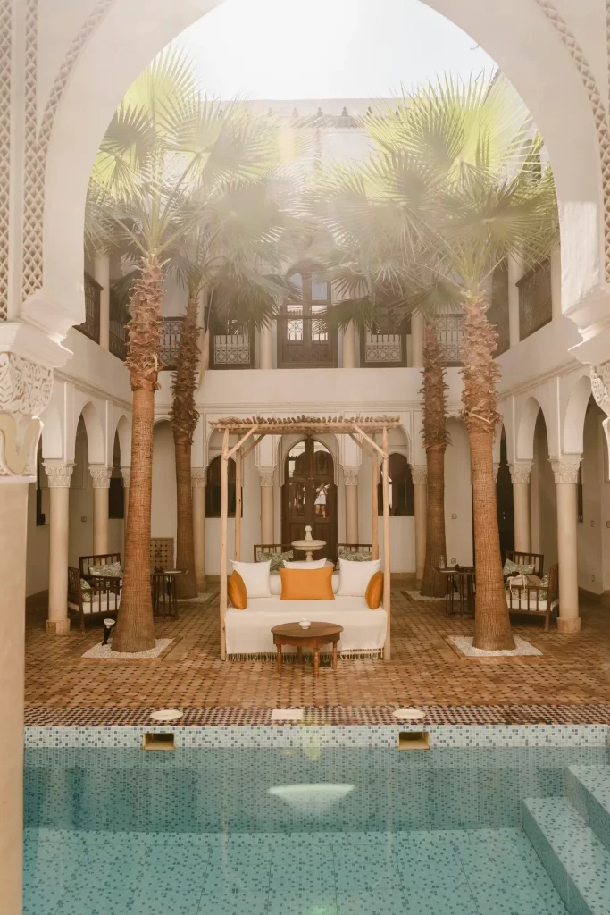 Patio de un riad con palmeras y piscina en Marrakech