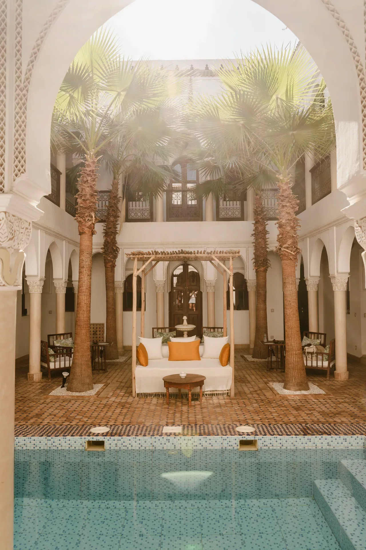 Patio de un riad con palmeras y piscina en Marrakech
