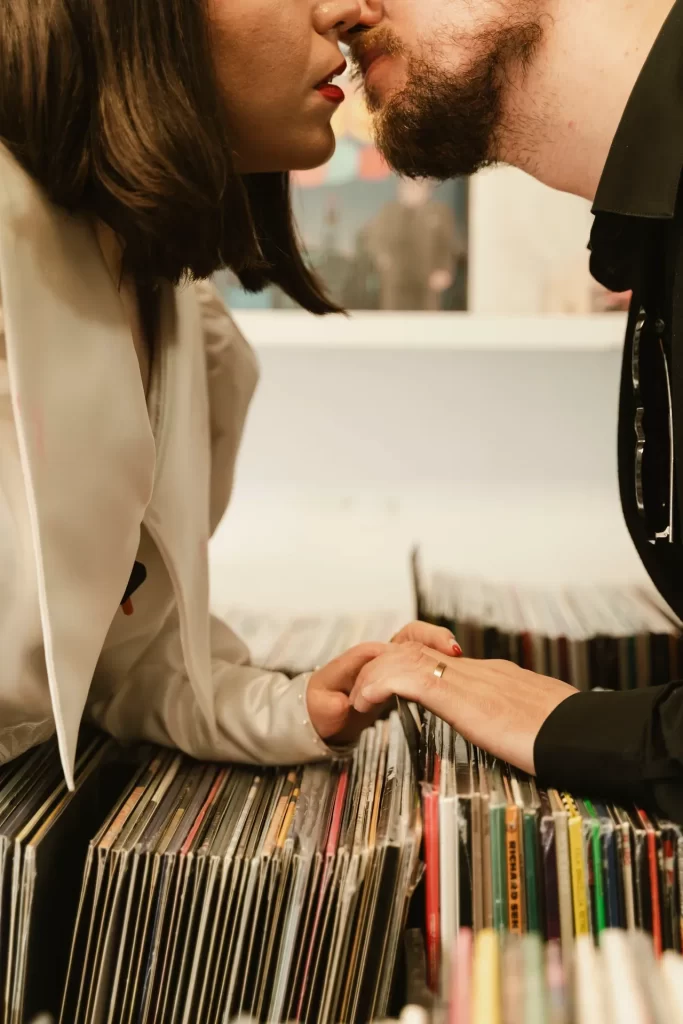 Pareja besándose sobre una caja de discos de vinilo