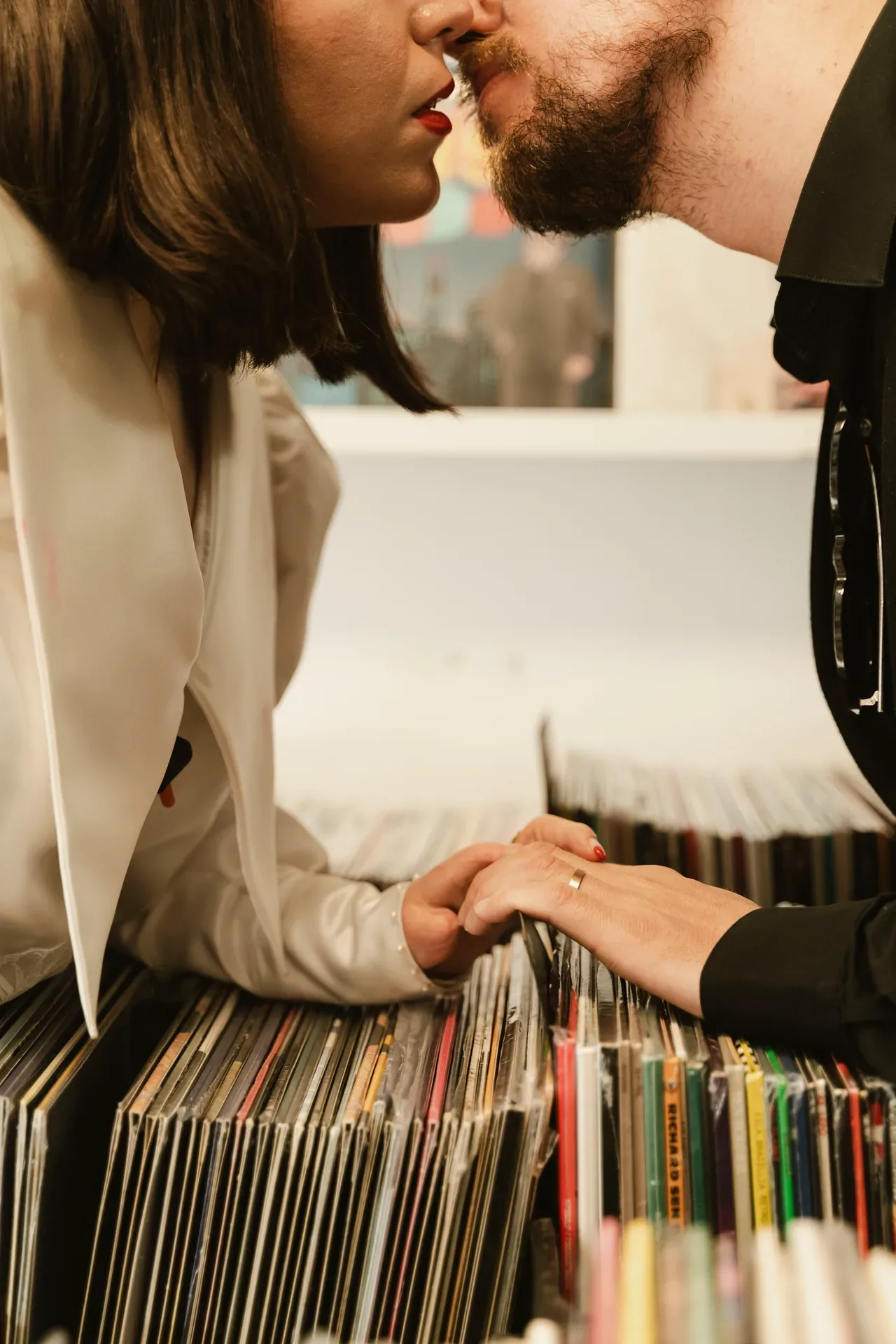 Pareja besándose sobre una caja de discos de vinilo